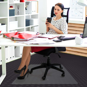 Picture showing a woman having a break at her office desk and using her protective floor mat for her office chair.