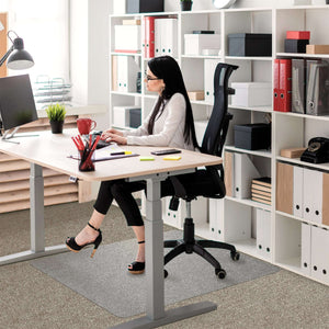 Picture showing the woman using her computer with the protective floor mat for her desk chair .