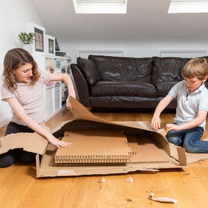 Showing 2 children putting together the eco easy childrens desk .