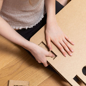 Showing a girl putting the eco easy home desk together from the honeycomb range.