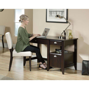 sit-stand home office desk in jamocha wood,  working in the sitting position of the sit or stand desk.